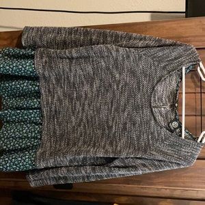 Heather’s gray sweater with floral pattern.